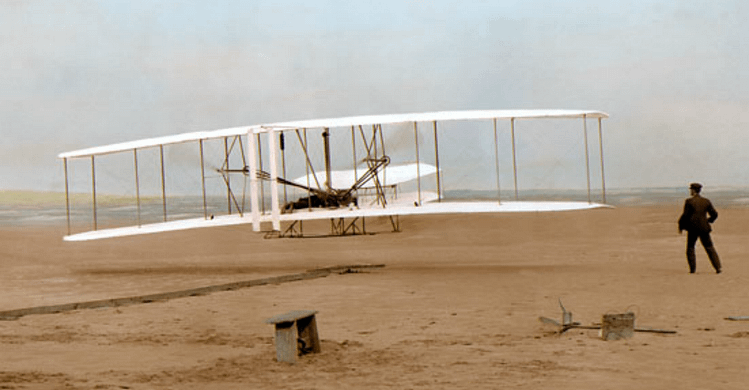 First Flight - colorized  photograph by John T. Daniels at Kitty Hawk in 1903, one of the most famous photos of all time.